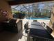 Outdoor kitchen with a built-in grill and dining area within a screened patio near the pool area at 375 Orange Cosmos Blvd, Davenport, FL 33837