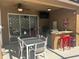 Outdoor living with a covered patio, ceiling fan, outdoor television, grill, bar seating and plush chairs at 375 Orange Cosmos Blvd, Davenport, FL 33837