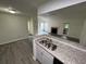 Charming kitchen featuring granite countertops, stainless steel sink, and an open view to the living room at 4200 Thornbriar Ln # 208, Orlando, FL 32822