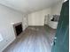 Open-concept living room with a vaulted ceiling, fireplace, and wood-look floors and access to kitchen area at 4200 Thornbriar Ln # 208, Orlando, FL 32822