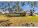 This backyard features a spacious lawn and a screened-in pool area, enhanced by mature trees and lush landscaping at 4815 Doc Dr, St Cloud, FL 34771
