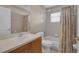 Bathroom features a vanity with a sink, a window, shower curtain, and a toilet at 4815 Doc Dr, St Cloud, FL 34771