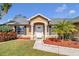 Inviting front entrance featuring decorative columns, a white door, and fresh landscaping around the foundation at 4815 Doc Dr, St Cloud, FL 34771