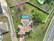 Aerial view of a home with a pool, screened enclosure, solar panels, and a fenced-in yard at 500 Viceroy Ct, Kissimmee, FL 34758