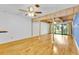 Spacious living room with hardwood floors, wood beams, fan, and sliding glass doors at 5311 Burning Tree Dr # D, Orlando, FL 32811