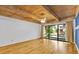 Open concept living room with hardwood floors, wood beam ceiling, fan, and backyard view at 5311 Burning Tree Dr # D, Orlando, FL 32811