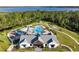 Stunning aerial view of a community pool and recreation area, nestled near a lake and wooded area at 6808 Cranes Roost Rd, Harmony, FL 34773