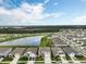Scenic aerial view of a residential community featuring a pond and well-maintained landscaping at 6808 Cranes Roost Rd, Harmony, FL 34773
