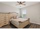 Charming bedroom featuring wood-look floors, neutral walls, and a matching dresser and nightstand at 6808 Cranes Roost Rd, Harmony, FL 34773