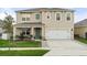 Charming two-story home features a well-manicured lawn, attached two-car garage, and welcoming front porch at 6808 Cranes Roost Rd, Harmony, FL 34773
