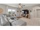 Cozy living room featuring a comfortable grey sectional sofa, ceiling fan, and bright window at 6808 Cranes Roost Rd, Harmony, FL 34773