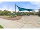 Playground with climbing structures, a slide, and shaded seating on a paved base at 6808 Cranes Roost Rd, Harmony, FL 34773