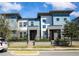 Modern townhomes with stylish blue and white exterior, well-maintained landscaping and black metal fences at 7381 Alpine Butterfly Ln, Orlando, FL 32819