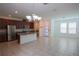 Open concept kitchen with stainless steel appliances, granite countertops and island with modern lighting at 7381 Alpine Butterfly Ln, Orlando, FL 32819