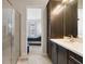 Bathroom view to bedroom featuring dark cabinets, white marble counters and glass shower at 7973 Greengard St, Orlando, FL 32827