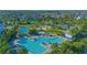 Aerial view of a community pool with many lounge chairs and manicured landscaping at 7973 Greengard St, Orlando, FL 32827