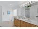 Bright bathroom featuring a soaking tub, double vanity, and a large mirror with great lighting at 8595 Sunrise Key Dr, Kissimmee, FL 34747