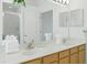 Bathroom featuring double sinks, quartz counters, wood cabinets, and glass-enclosed shower at 8595 Sunrise Key Dr, Kissimmee, FL 34747