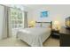 Bright, inviting bedroom featuring a queen bed, large window and soft, neutral colors at 8595 Sunrise Key Dr, Kissimmee, FL 34747
