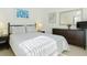 Comfortable bedroom featuring a queen-sized bed, neutral colors, and dark wood furnishings at 8595 Sunrise Key Dr, Kissimmee, FL 34747