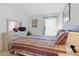 Cozy bedroom with a queen bed, neutral decor, and a bright window with sheer curtains at 8595 Sunrise Key Dr, Kissimmee, FL 34747