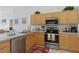 Well-equipped kitchen with stainless steel appliances, light wood cabinets, and ample countertop space at 8595 Sunrise Key Dr, Kissimmee, FL 34747