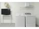 White laundry room featuring full size washer and dryer plus shelving and a wall mounted fan at 8595 Sunrise Key Dr, Kissimmee, FL 34747
