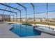 Inviting screened-in pool area with a built-in spa, and lush landscaping at 8595 Sunrise Key Dr, Kissimmee, FL 34747