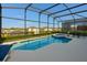 Enclosed pool area featuring a screened-in pool and an attached jacuzzi, plus patio seating at 8595 Sunrise Key Dr, Kissimmee, FL 34747