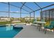 Screened-in in-ground pool with a hot tub and lounge furniture offering a relaxing outdoor space at 8595 Sunrise Key Dr, Kissimmee, FL 34747