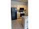 Galley kitchen featuring tan cabinets, black appliances and tile floors at 8927 Legacy Ct # 302, Kissimmee, FL 34747