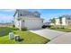 Two-story home with two-car garage, manicured lawn, and concrete driveway leading up to the house at 1562 Delightful Dr, Davenport, FL 33896
