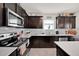 Charming kitchen boasts dark wood cabinets, stainless steel appliances, and subway tile backsplash at 1562 Delightful Dr, Davenport, FL 33896