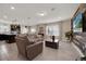 Open-concept living area with contemporary furnishings, complemented by a decorative wood accent wall at 1562 Delightful Dr, Davenport, FL 33896