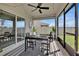 Inviting screened-in patio featuring a ceiling fan, black table and chairs, and modern decor at 1562 Delightful Dr, Davenport, FL 33896
