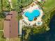 Aerial view of a community pool, spa and clubhouse with nearby lake providing a refreshing escape at 8708 Papaya Dr, Kissimmee, FL 34747