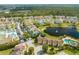 Aerial view of a community with a lake, fountain, pool, and well-maintained landscaping, creating a serene environment at 8708 Papaya Dr, Kissimmee, FL 34747