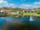 Scenic view of a community with a lake, fountain, pool, and well-maintained landscaping, creating a serene environment at 8708 Papaya Dr, Kissimmee, FL 34747