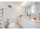 Bright bathroom with large mirror, white cabinetry, ample counter space, and shower/tub combo at 8708 Papaya Dr, Kissimmee, FL 34747
