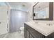 Modern bathroom with a dark vanity, stylish mirror, and shower with curtain at 8708 Papaya Dr, Kissimmee, FL 34747