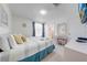 Bright bedroom with a window, blue-and-white striped bedspread, ensuite bathroom and a desk at 8708 Papaya Dr, Kissimmee, FL 34747