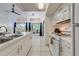 Modern kitchen with white cabinets, open to the living room and dining area, and terrace views at 8708 Papaya Dr, Kissimmee, FL 34747