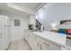 Bright kitchen with white cabinets and stainless-steel sink, open to the living space and staircase at 8708 Papaya Dr, Kissimmee, FL 34747