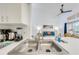 Stainless steel double kitchen sink with a view to the living room and its vaulted ceiling at 8708 Papaya Dr, Kissimmee, FL 34747
