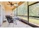 Relaxing screened-in porch with a ceiling fan, dining set, and views of the lush green landscape at 8708 Papaya Dr, Kissimmee, FL 34747
