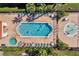 Aerial view of the community pool, hot tub, and splashpad with chairs, tables, and landscaping at 1007 Park Ridge Cir, Kissimmee, FL 34746