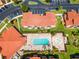 An aerial view of the community showcasing the pool, splashpad, parking area, and red tile roofs at 1007 Park Ridge Cir, Kissimmee, FL 34746