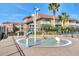 Exterior view of colorful townhomes overlooking the splashpad with palm trees and mature landscaping at 1007 Park Ridge Cir, Kissimmee, FL 34746