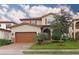 Charming two-story home featuring a tile roof, arched entry, and a well-manicured lawn at 10467 Henbury St, Orlando, FL 32832