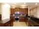 Functional kitchen featuring dark wood cabinetry, stainless steel appliances, and tile backsplash at 10467 Henbury St, Orlando, FL 32832